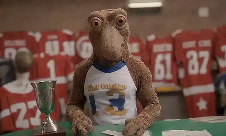 Paul el octopus con trofeo rodeado de jerseys y tablero de apuestas